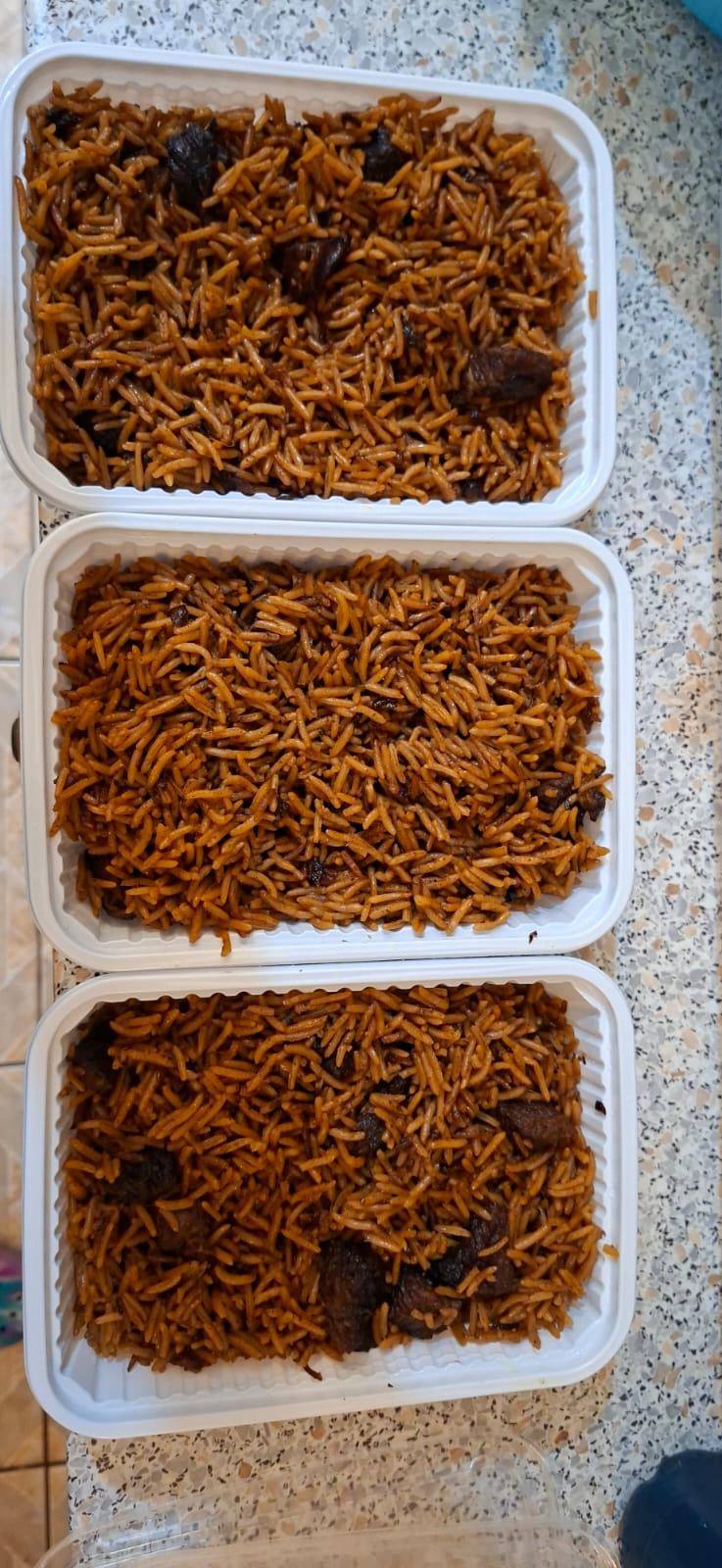 Large catering trays of Kenyan pilau rice prepared for a party
